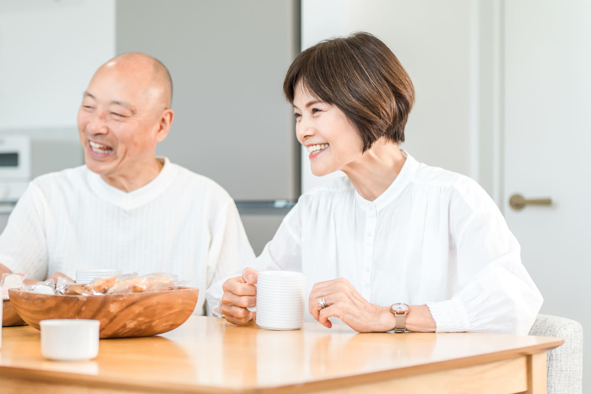 コーヒーを飲みながら家族と会話する笑顔のシニア夫婦