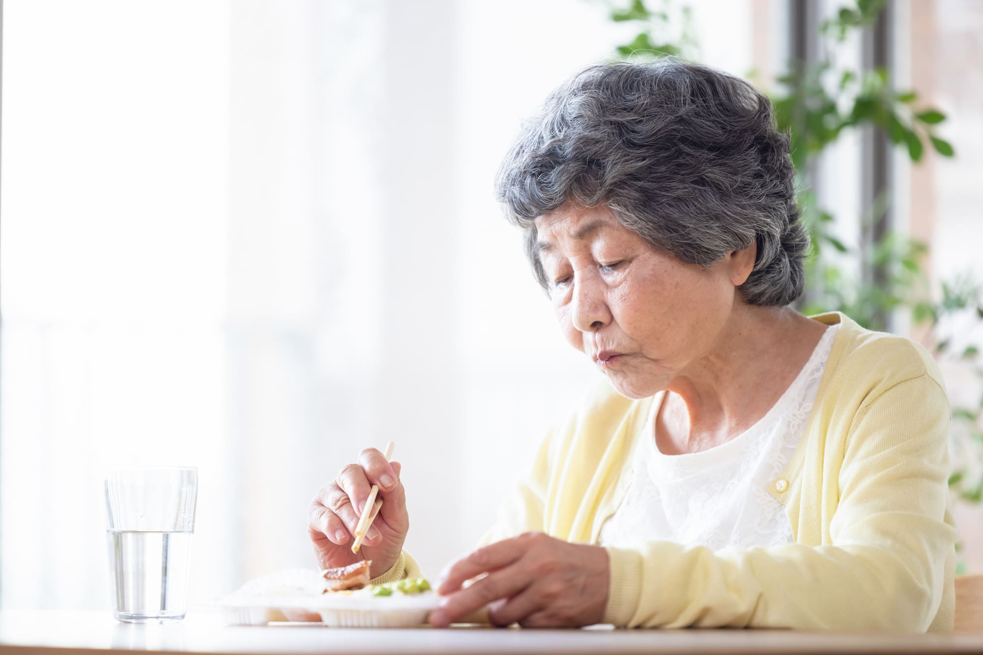 一人で食事をしているシニア女性