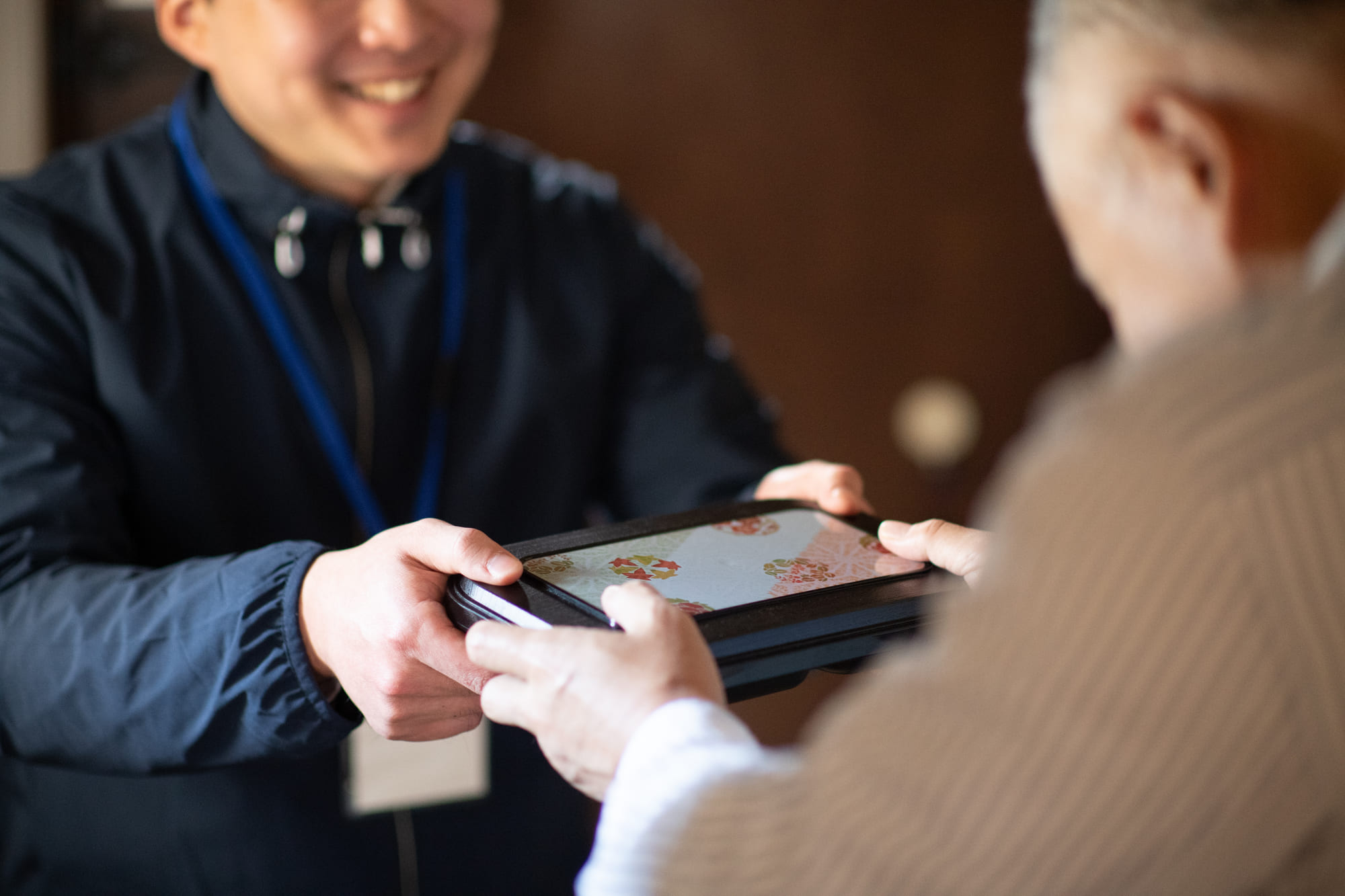 お弁当を受け取る高齢の男性