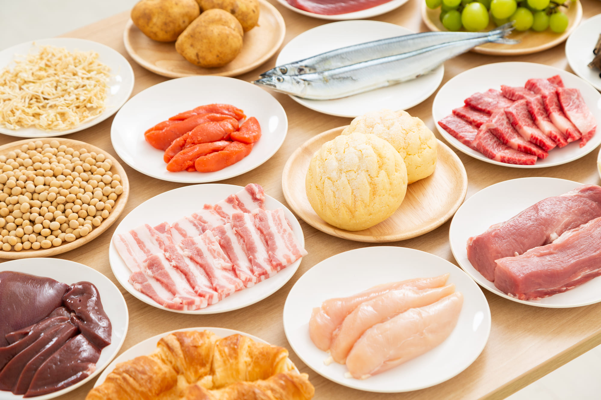 皿に乗せられて並んだ肉や魚、パンといった食材