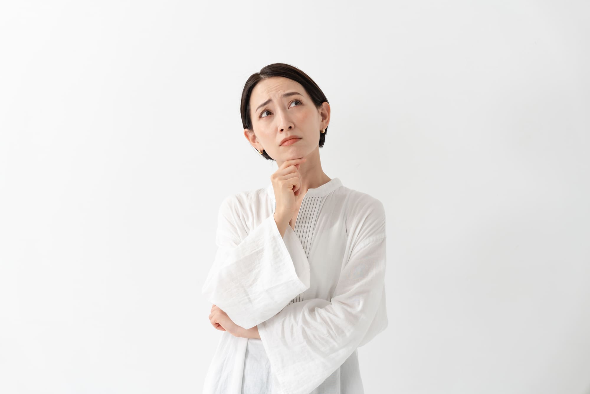 顎に手を当てて考えるミドル女性