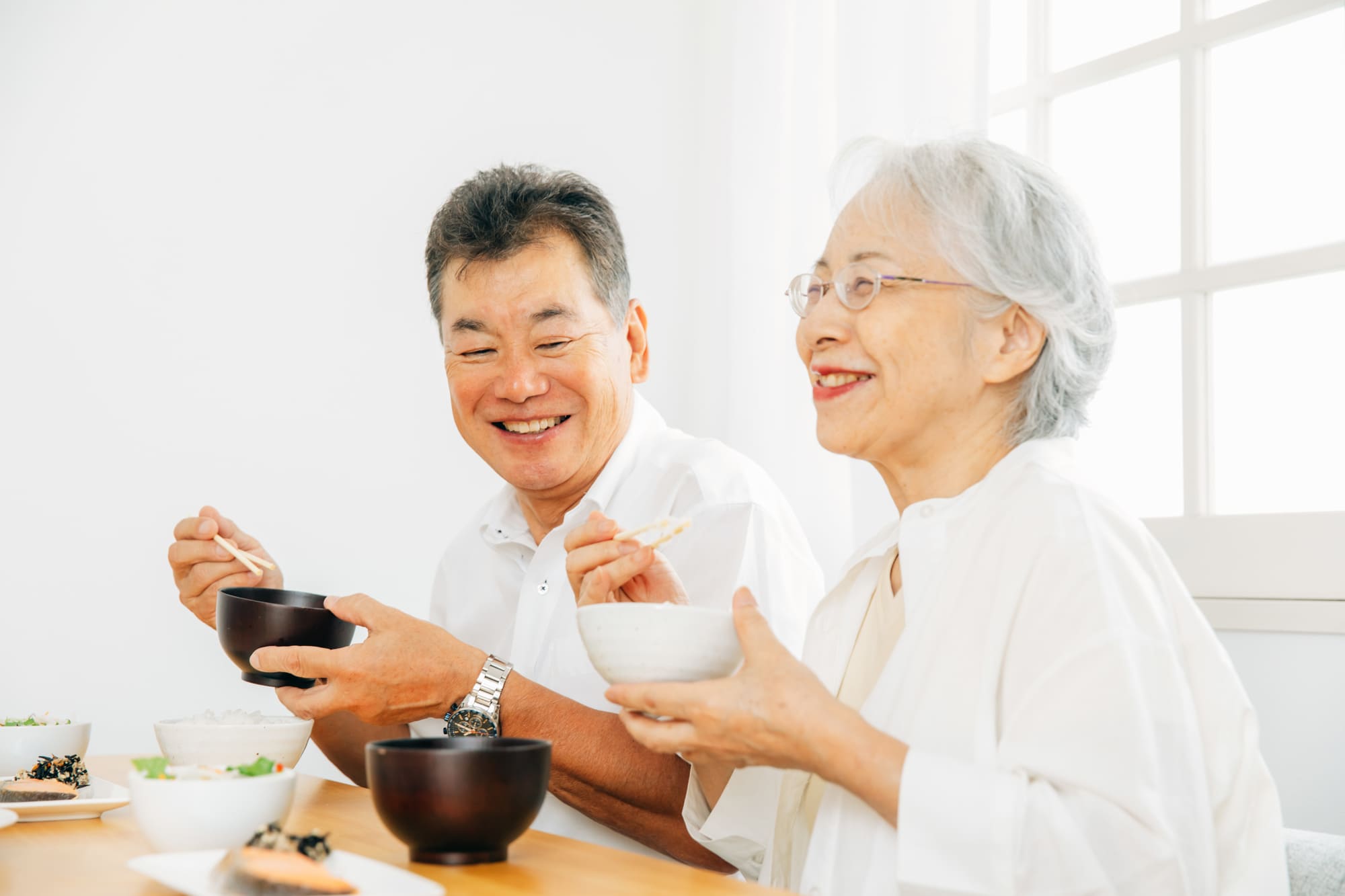 笑顔で食事を楽しむシニア夫婦