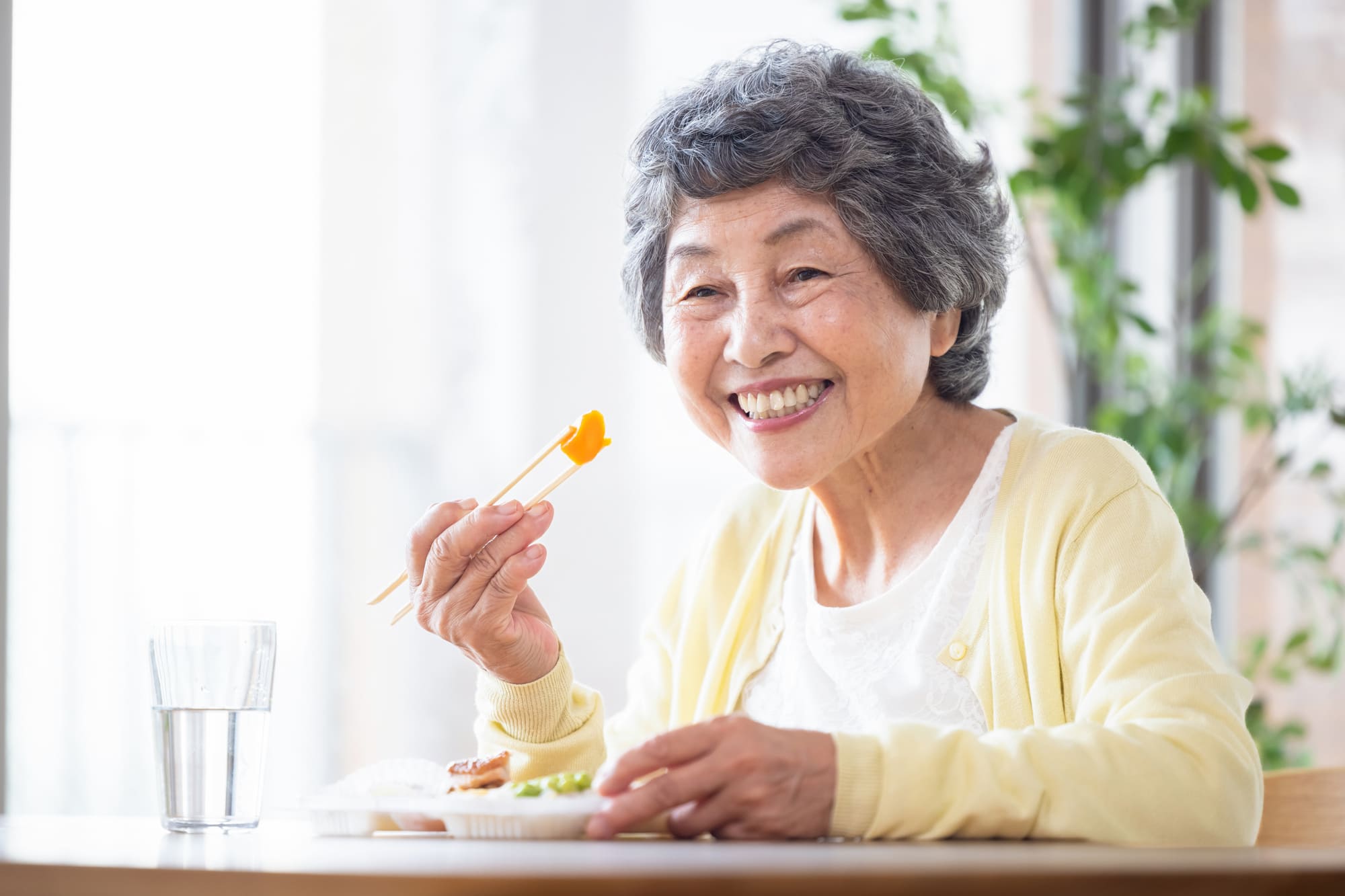 笑顔で食事を楽しむシニア女性