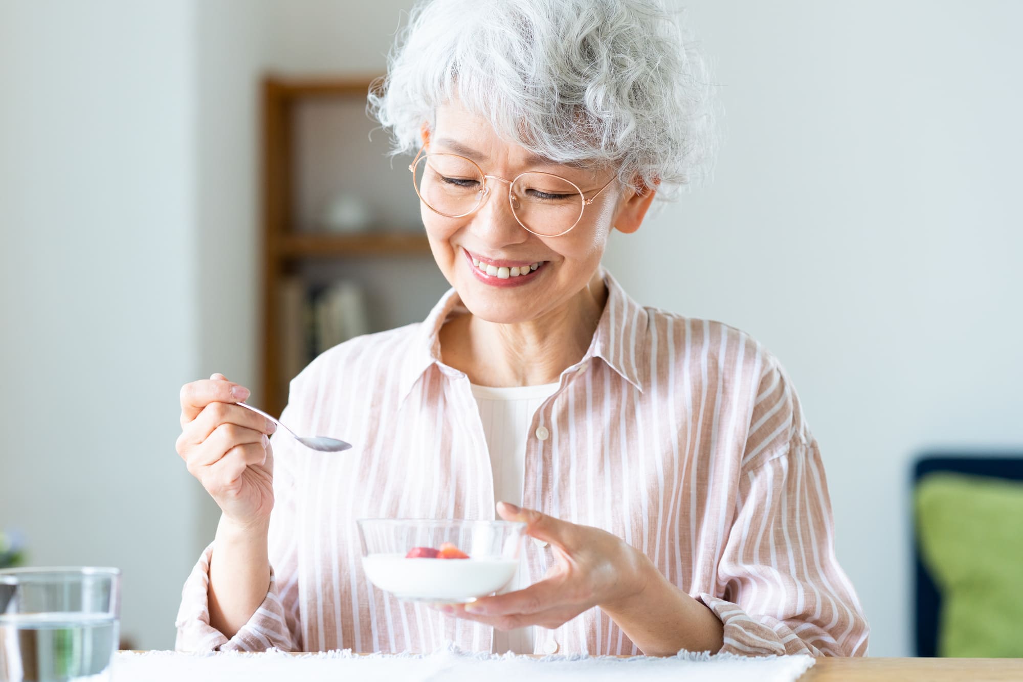 ヨーグルトを食べるシニア女性