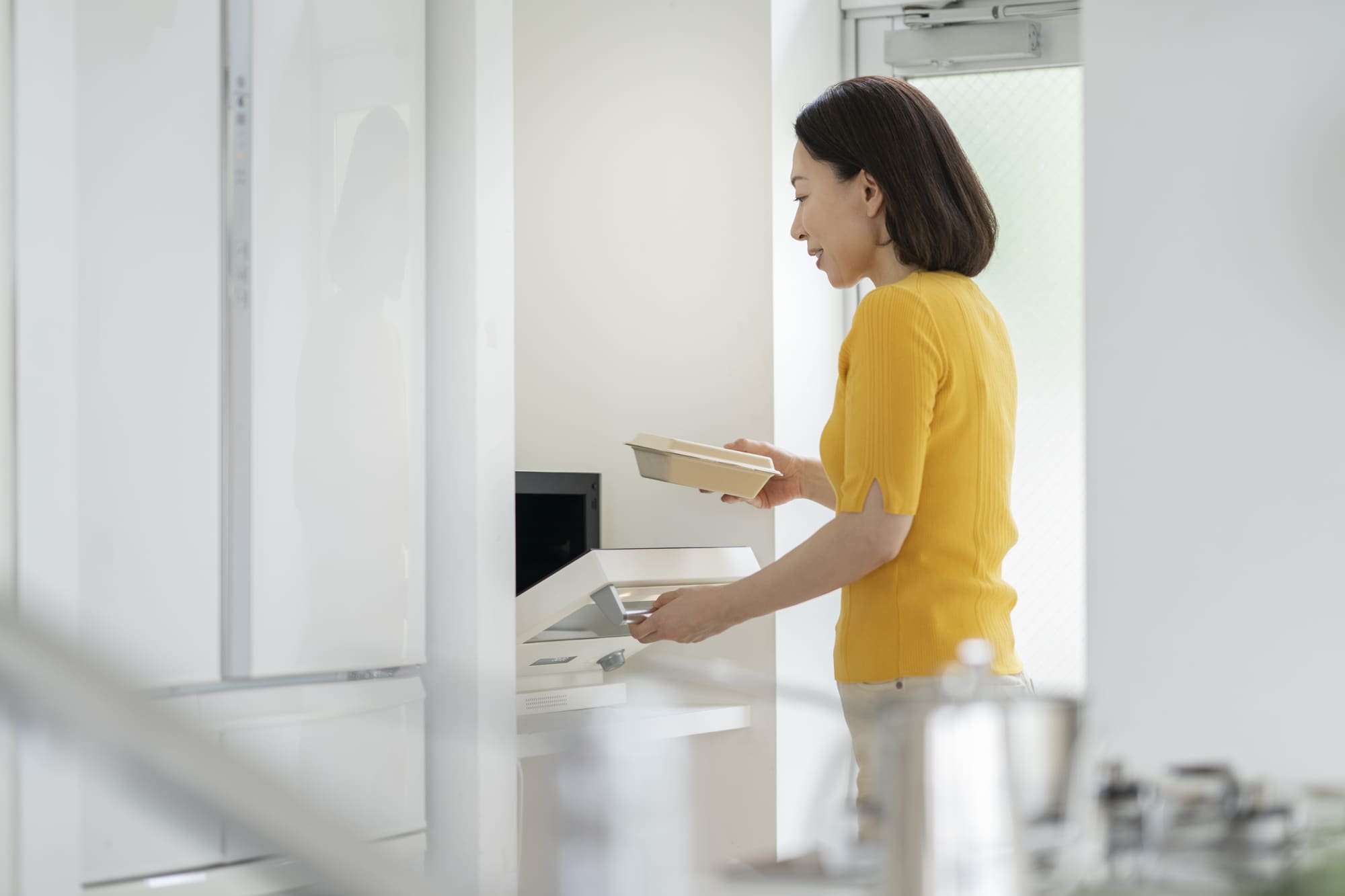 電子レンジでお弁当を温めるミドル女性