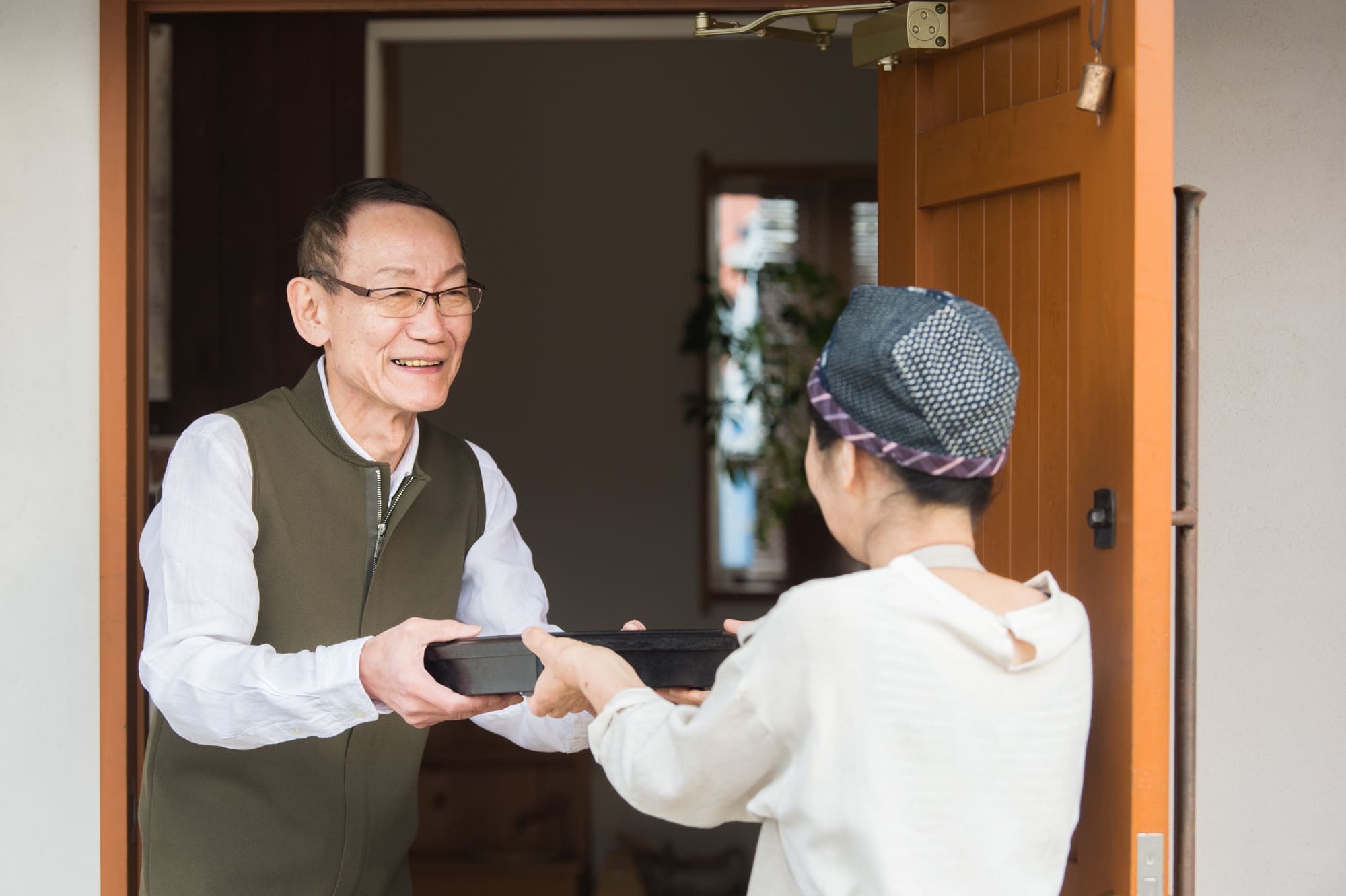 スタッフから弁当を受け取っている男性