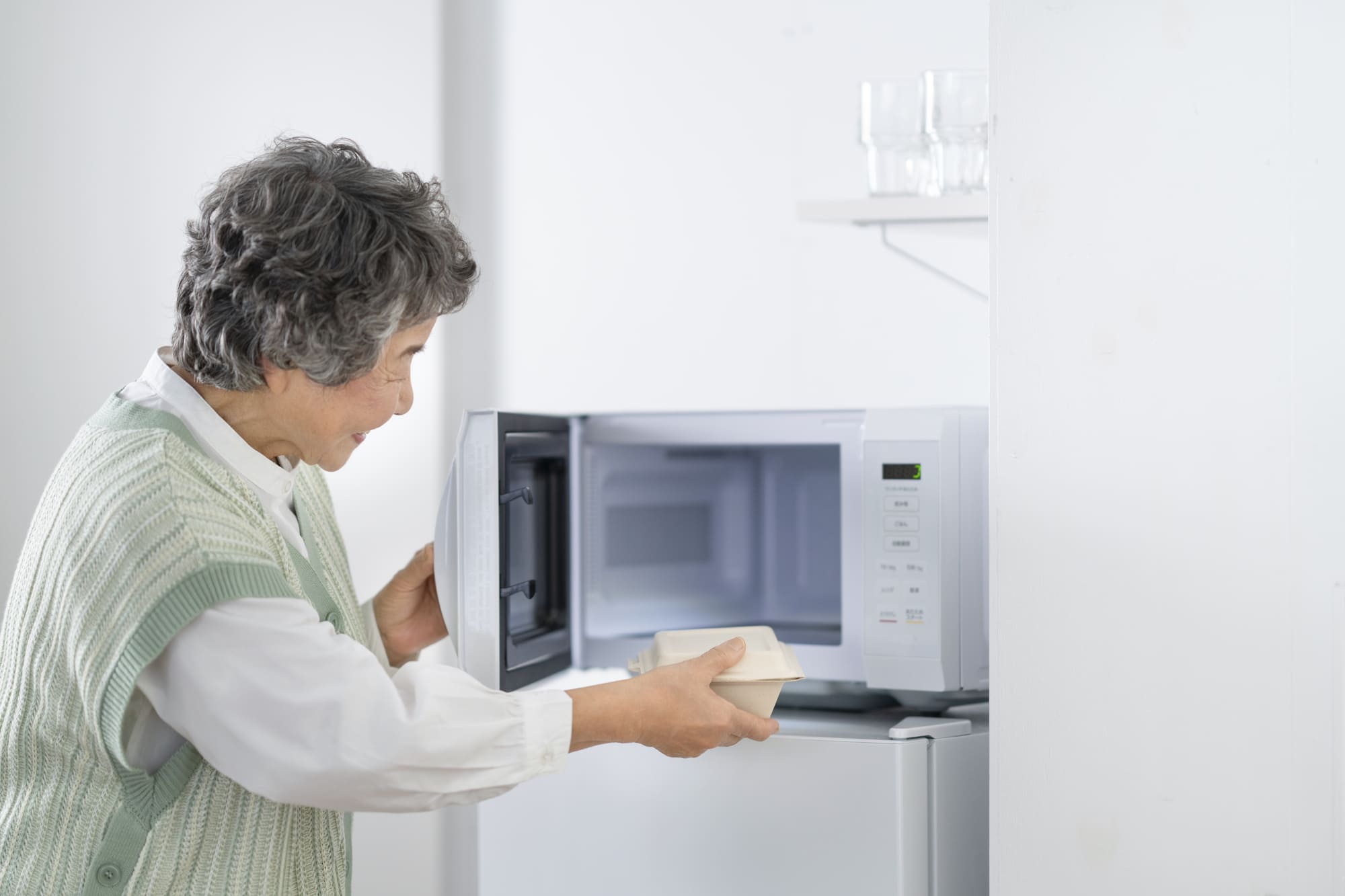 弁当のふたを開けている男性の手元