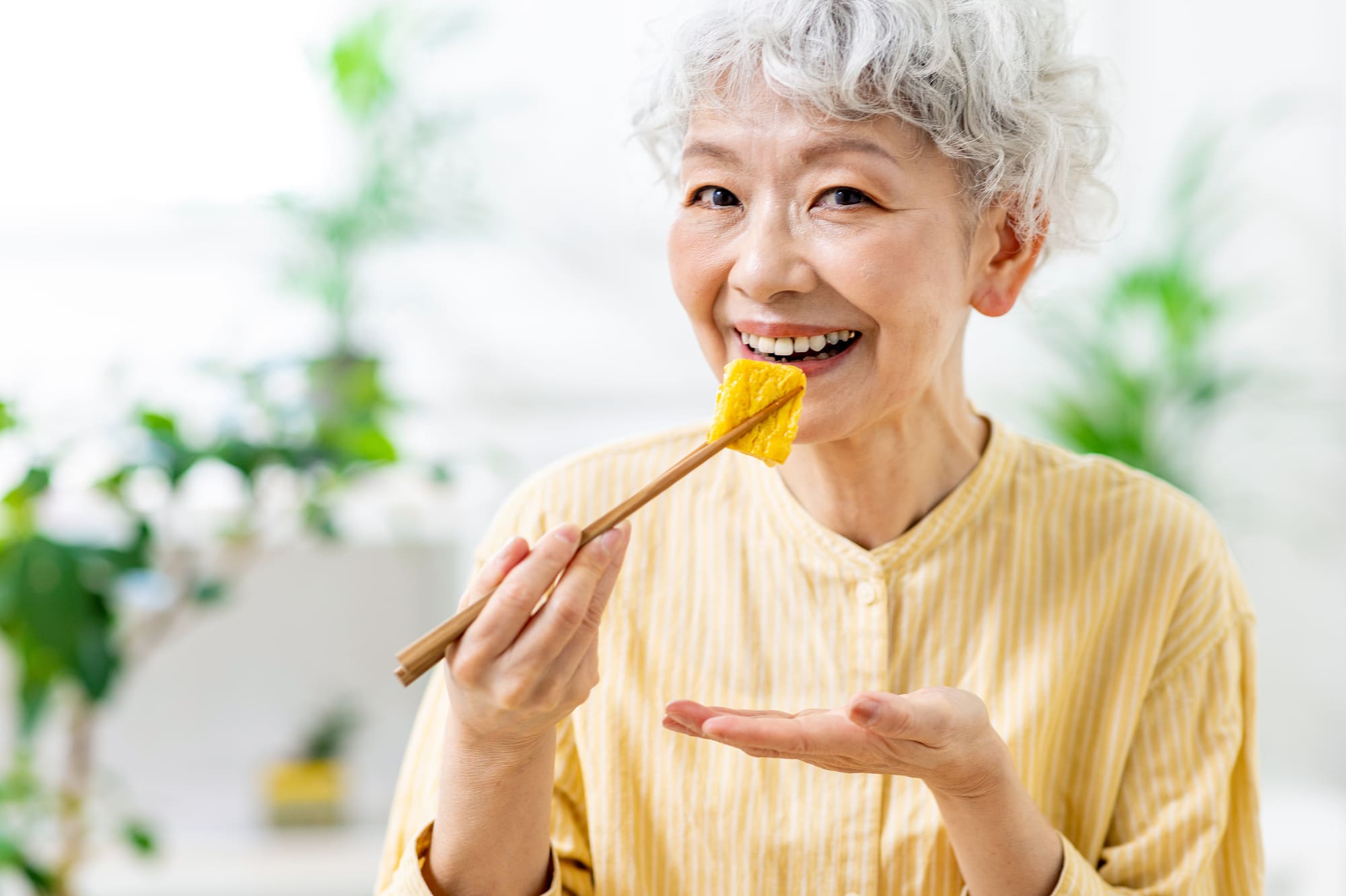 笑顔で食事をするシニア女性