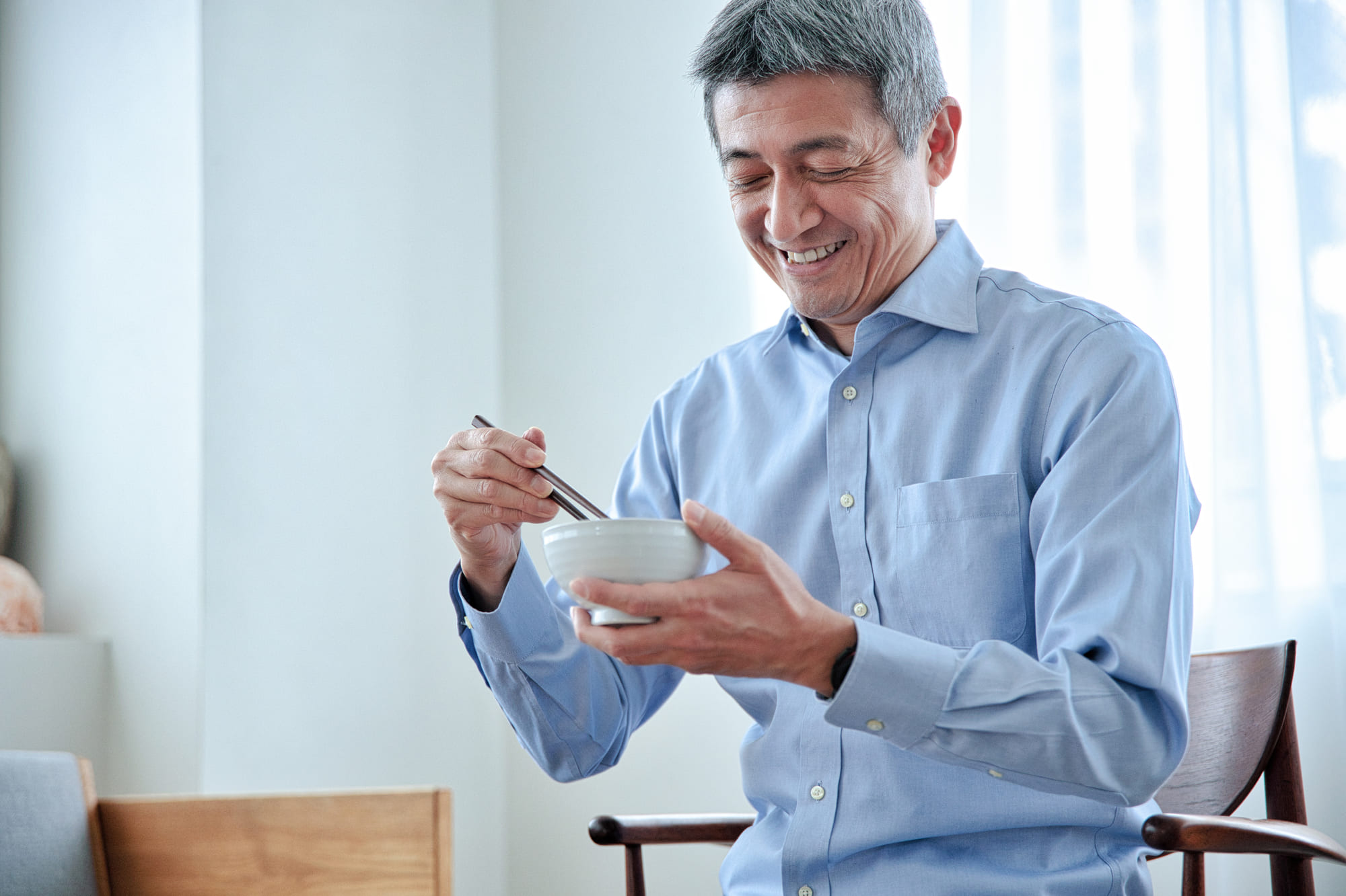 笑顔でごはんを食べるシニア男性