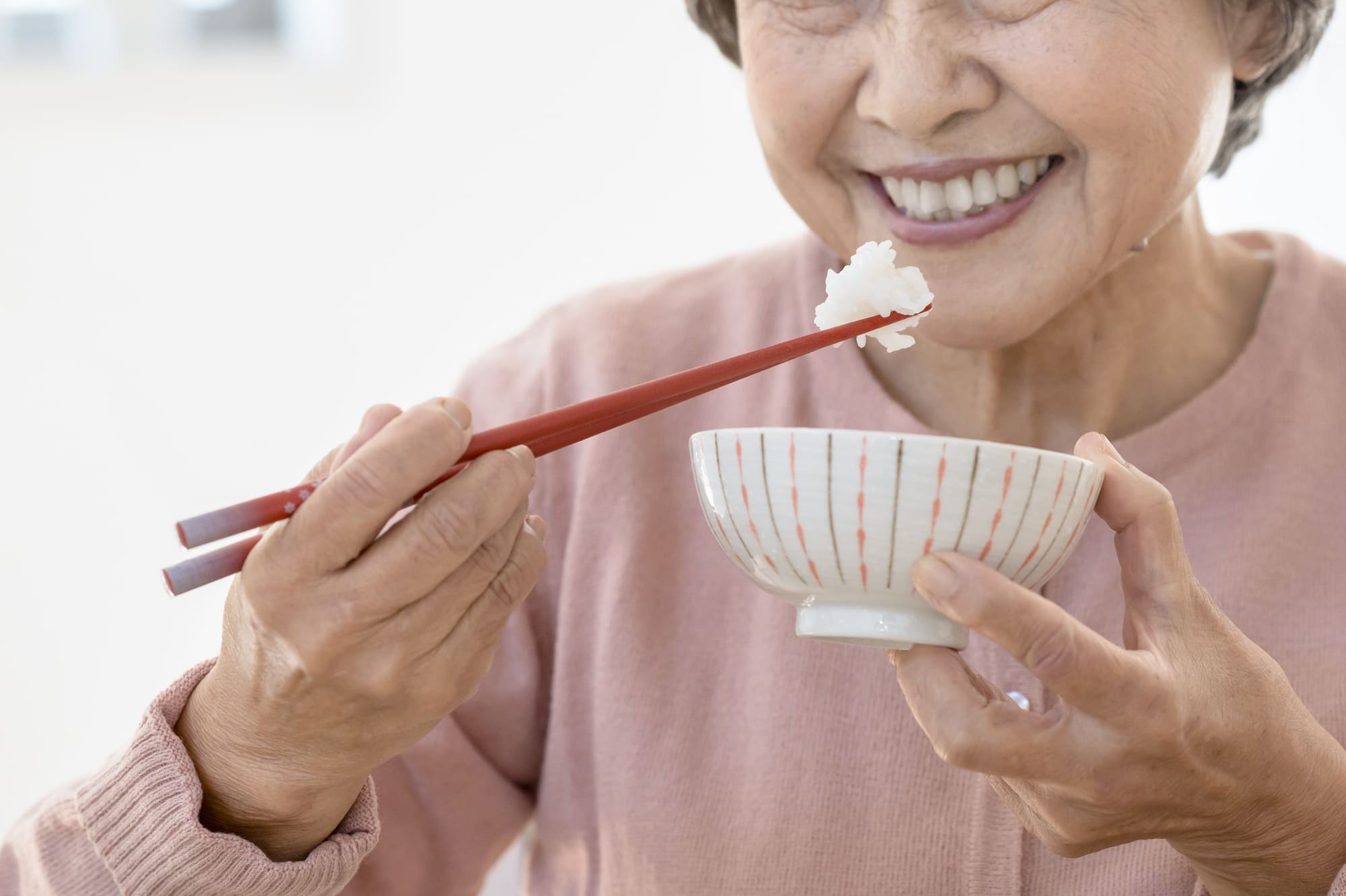ごはんを食べるシニア女性の手元