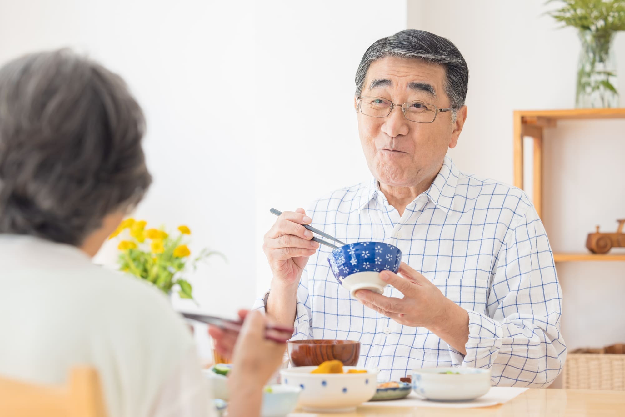 笑顔でごはんを食べるシニア夫婦