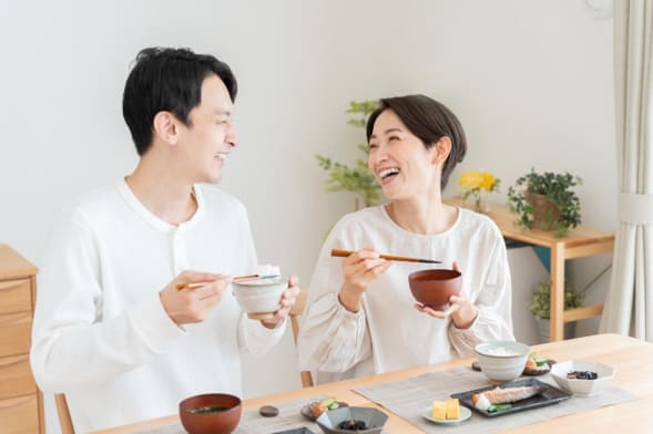 笑顔でごはんを食べるミドル夫婦