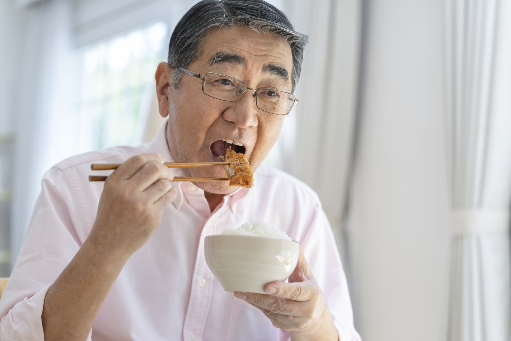 食事をしているシニア男性