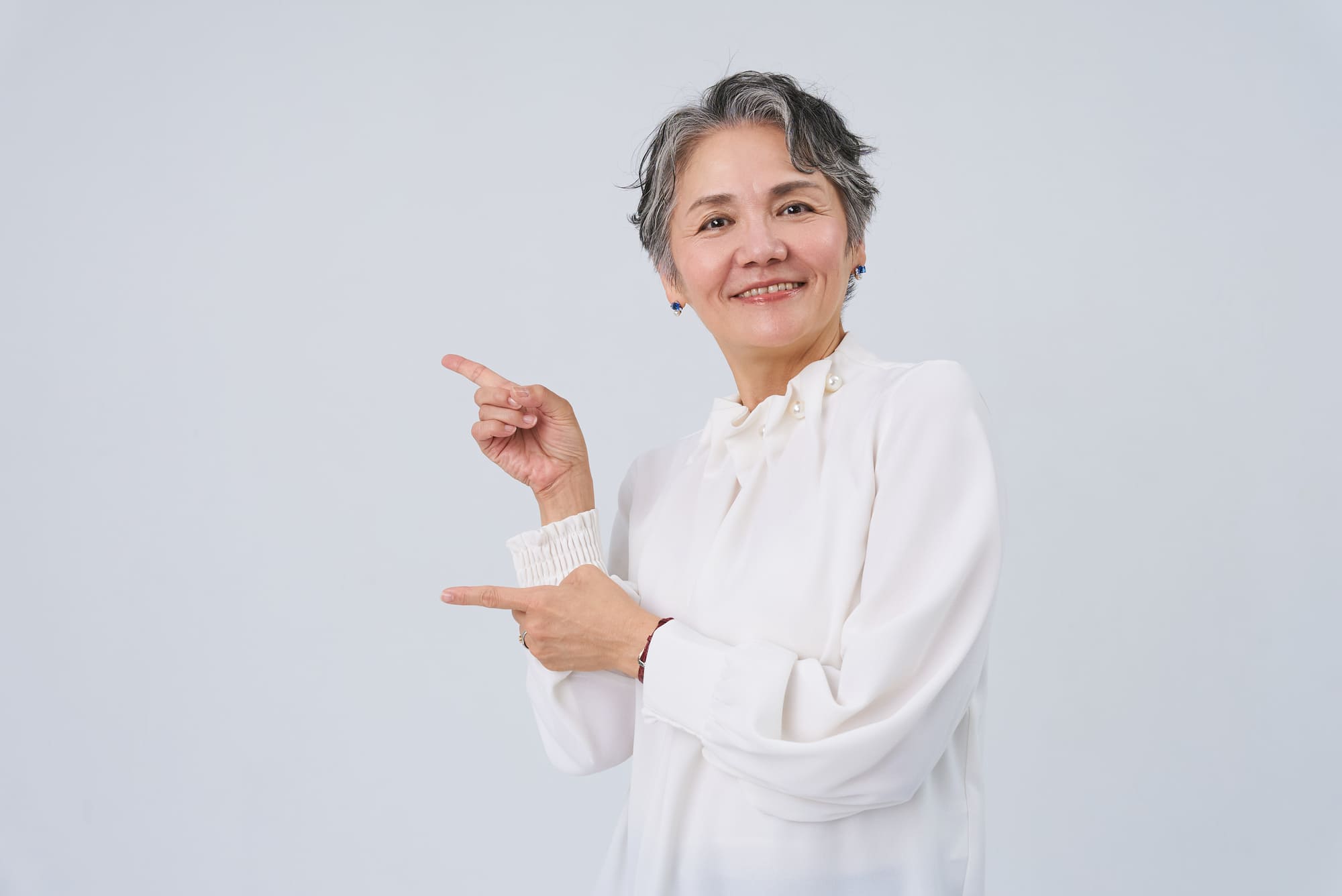 両手でポイントを示す笑顔の女性