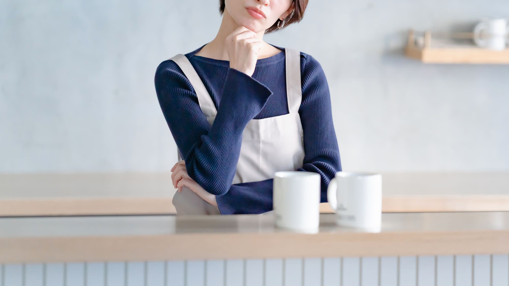 キッチンで考え込む女性