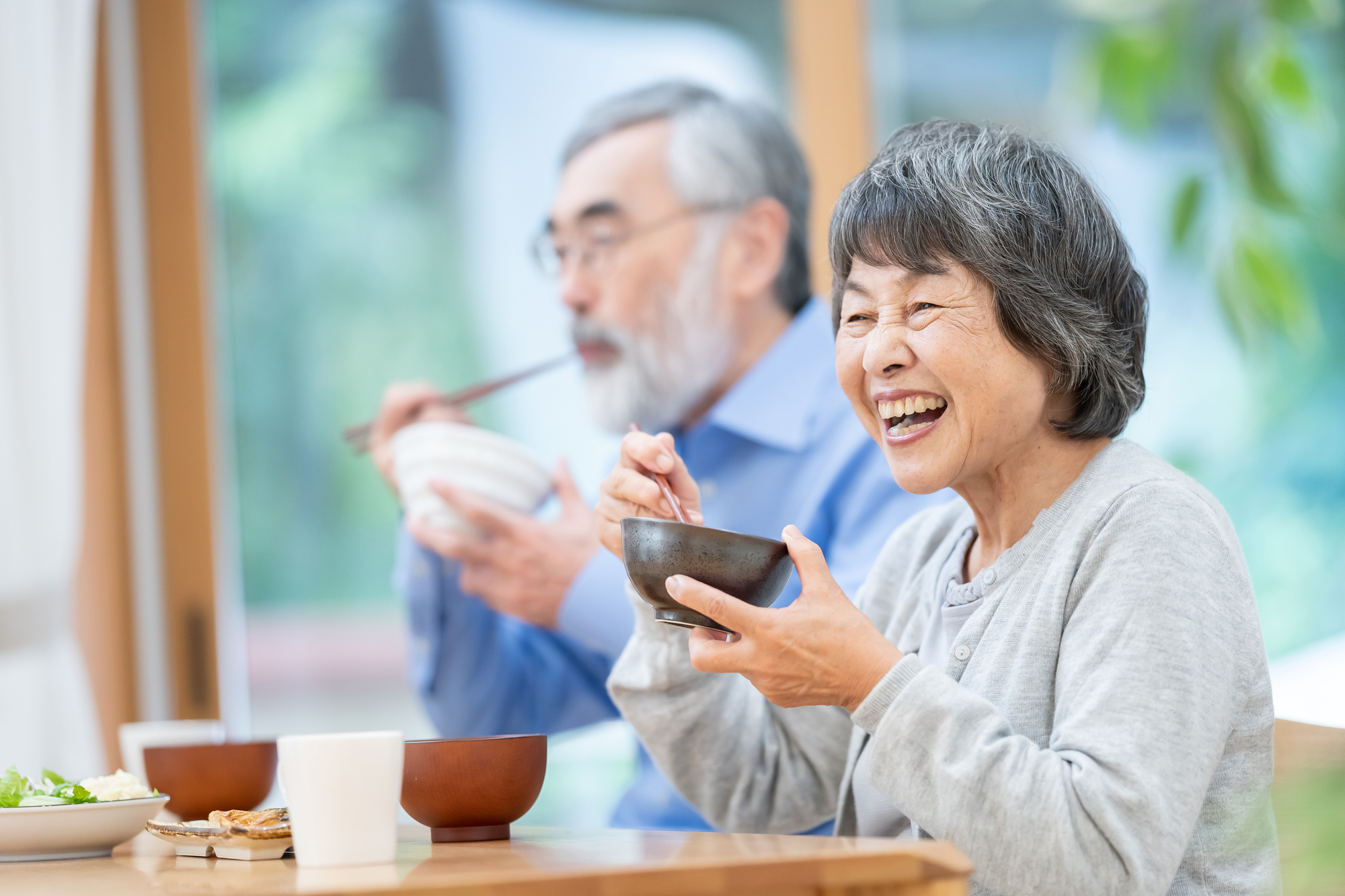 笑顔で食事をするシニア夫婦