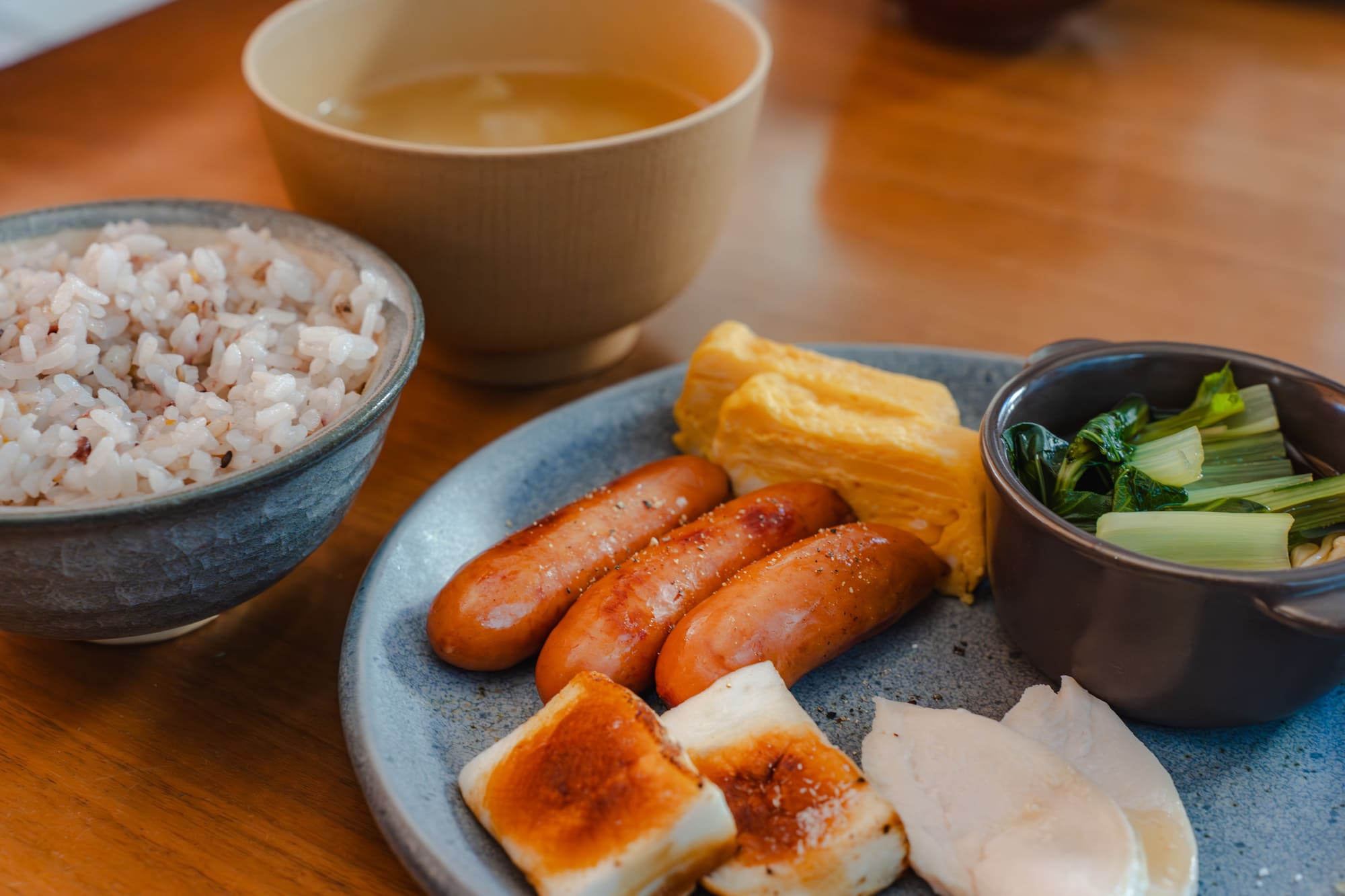 鶏むね肉や玉子焼きが乗った皿とごはん、みそ汁
