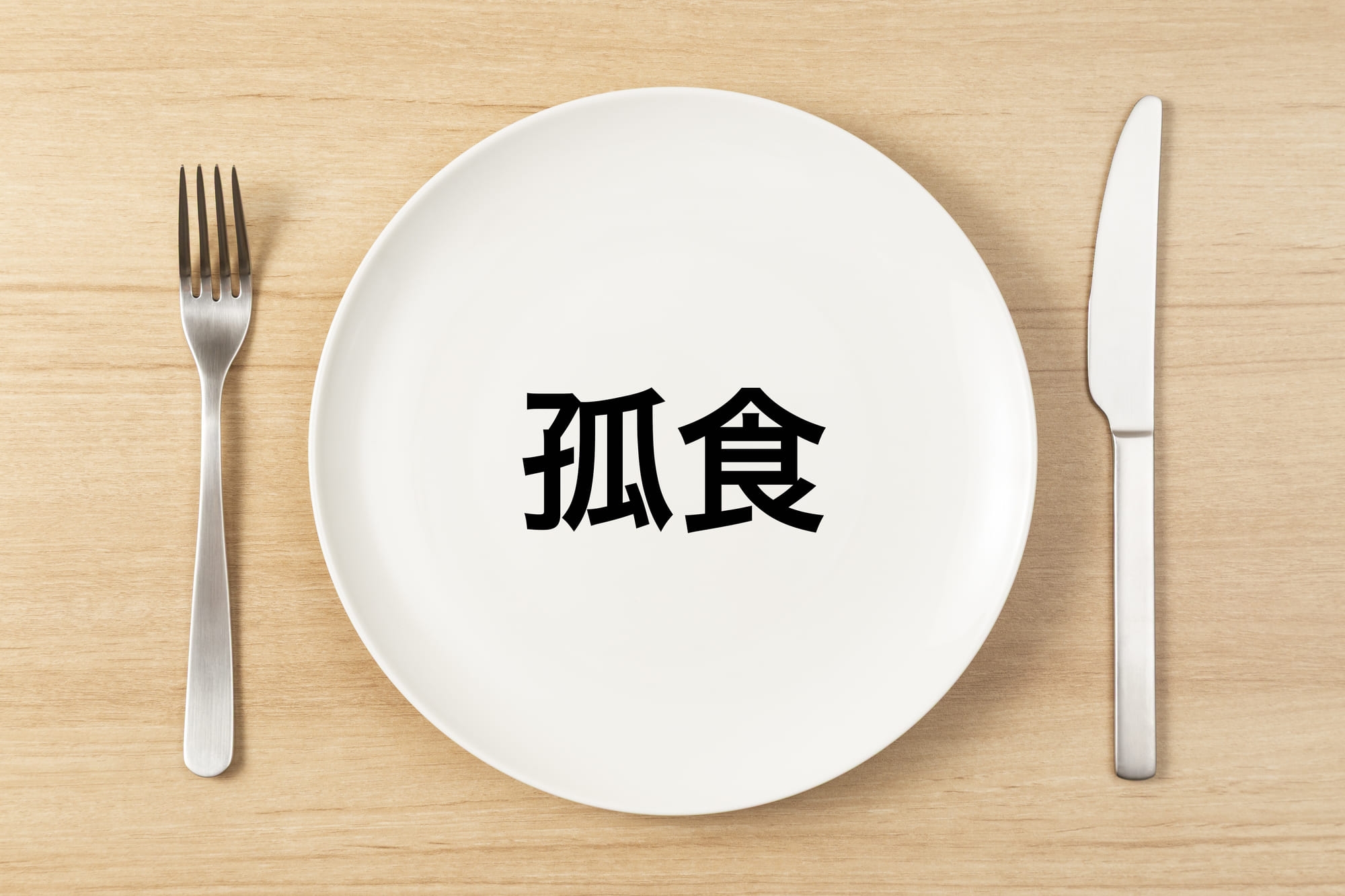 「孤食」と書かれた皿とカトラリー