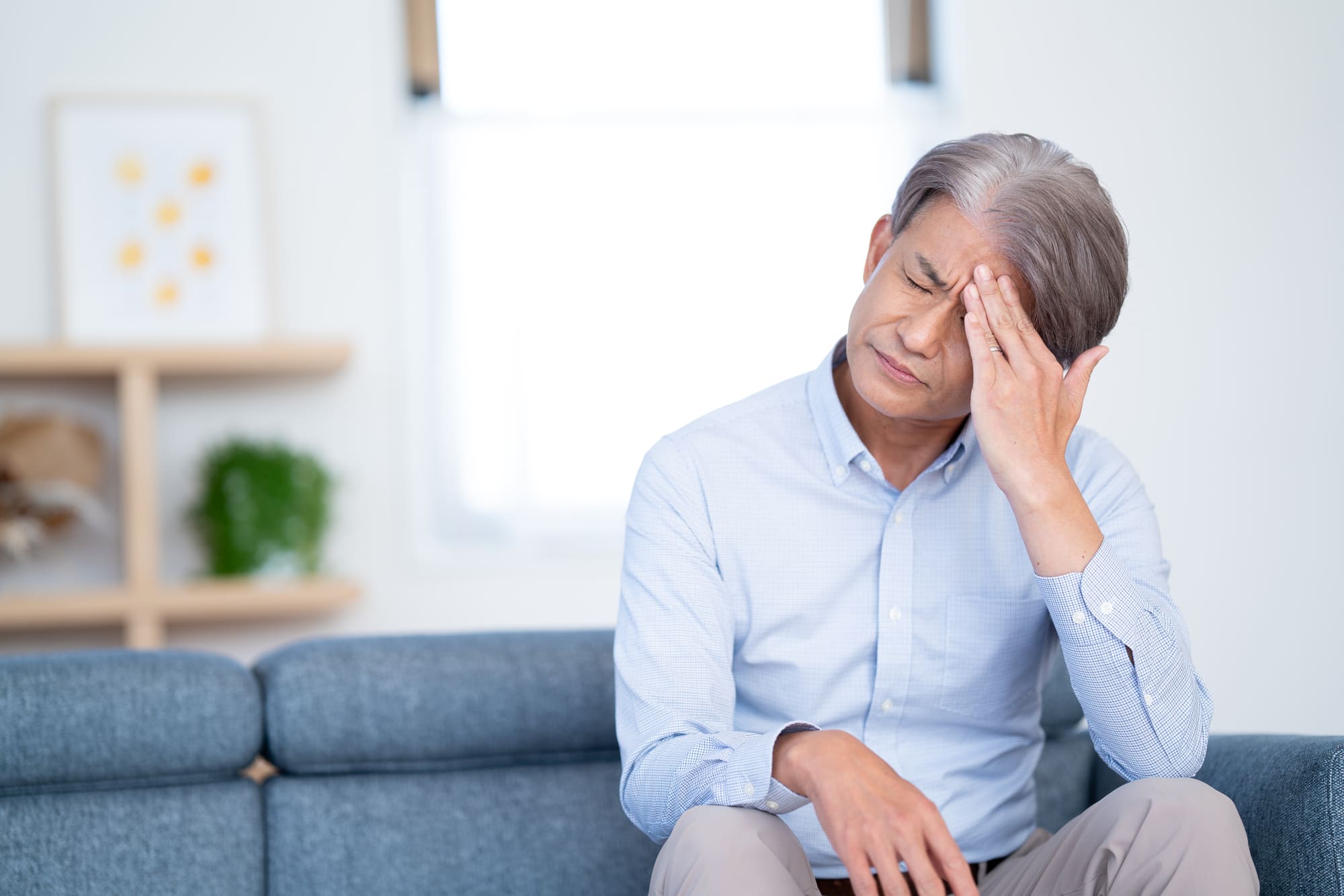 額に手を当て、眉間にしわを寄せた男性
