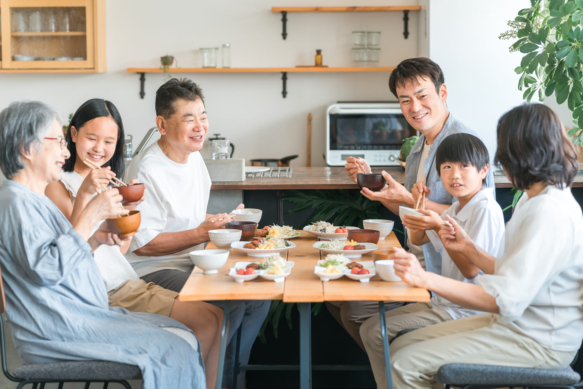笑顔で食事をする3世帯家族