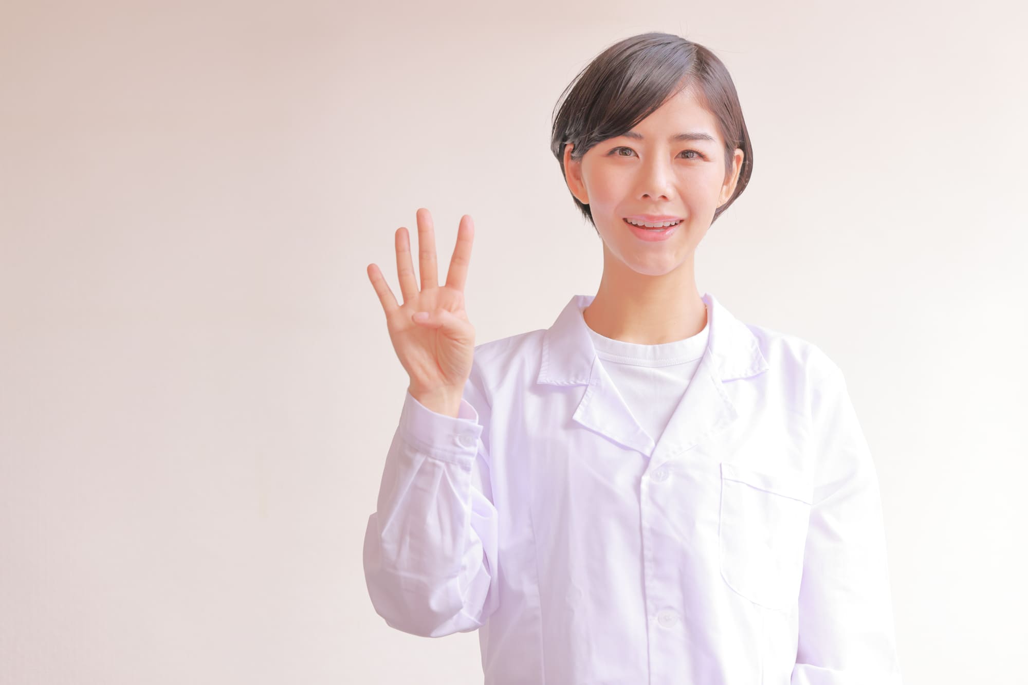 4本指を立てた笑顔の女性