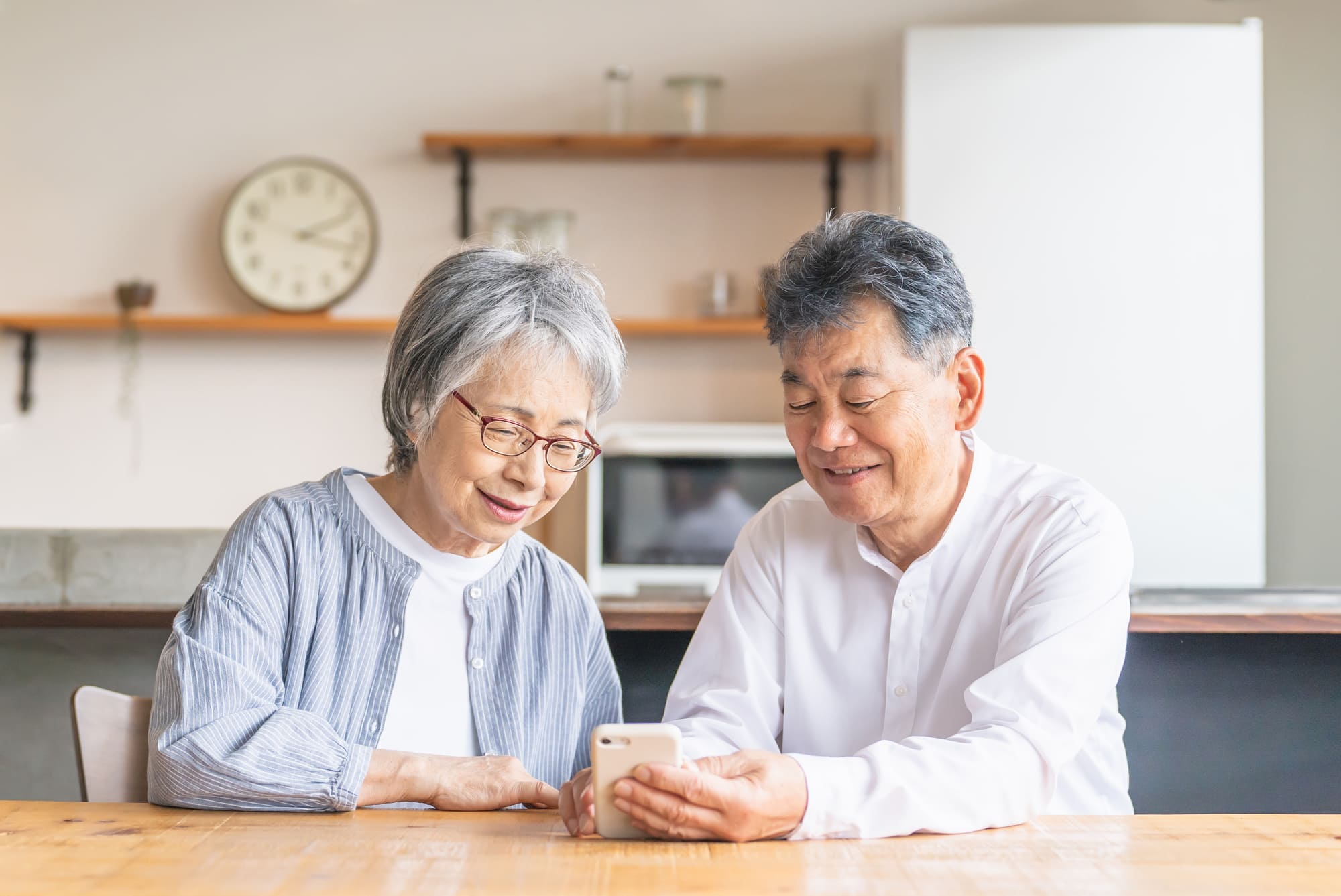 自宅でスマホを使って調べ物をするシニア夫婦