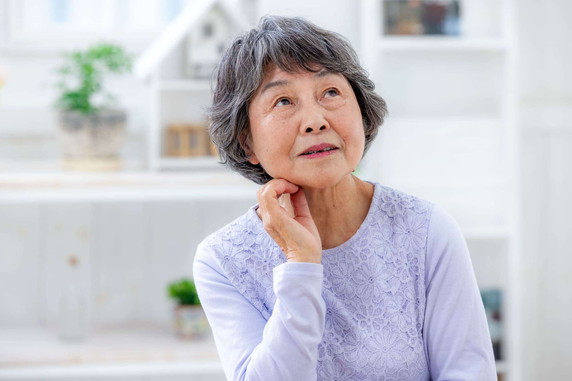 考え事をしているシニア女性