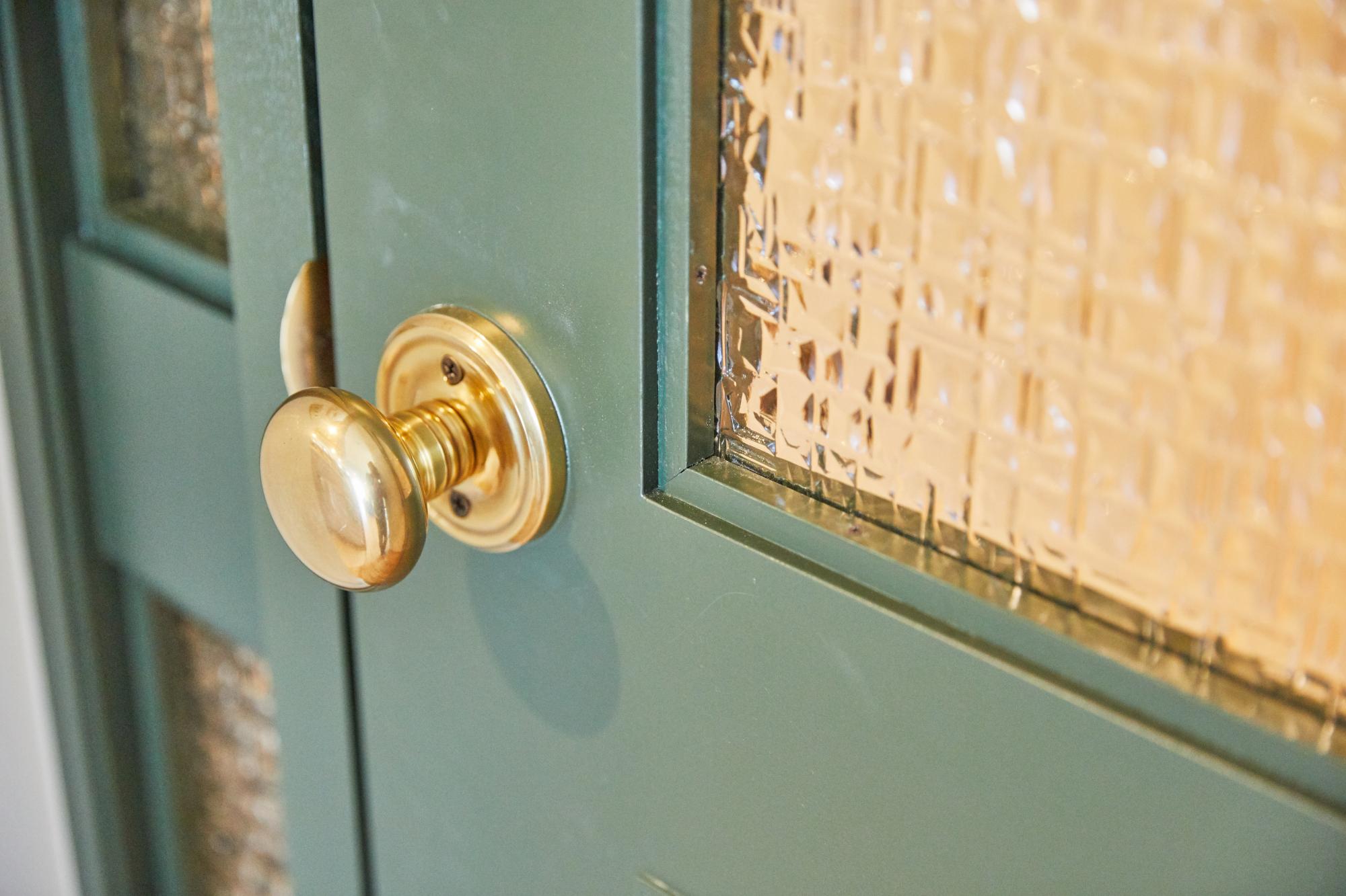 観葉植物がよく映える、グリーンのデザインドアのリノベーション事例