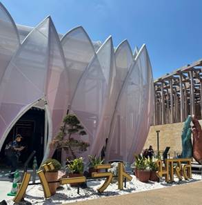 A building with a white structure with a white flower shaped entrance
Description automatically generated with medium confidence