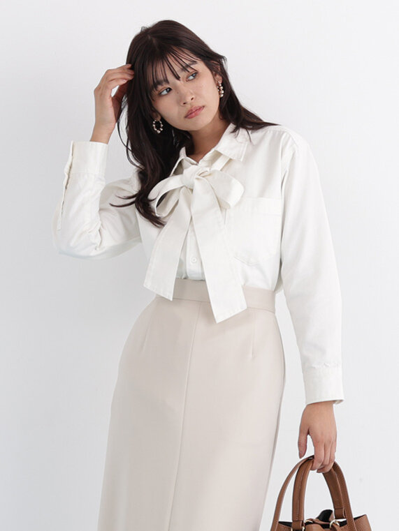 ホワイトデニムシャツにベージュのひざ丈タイトスカート。ブラウンのハンドバッグを合わせてワントーンベージュコーデ。