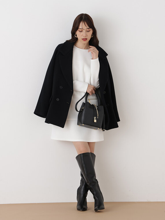 ホワイトのミニワンピースにブラックのコートと、小物でひざ丈ブーツ、ブラックのバッグを合わせたコーディネート
