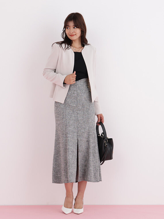 ベージュのショート丈ジャケットにブラックのプルオーバー、ブラックのツイードマーメイドスカートのコーディネート。