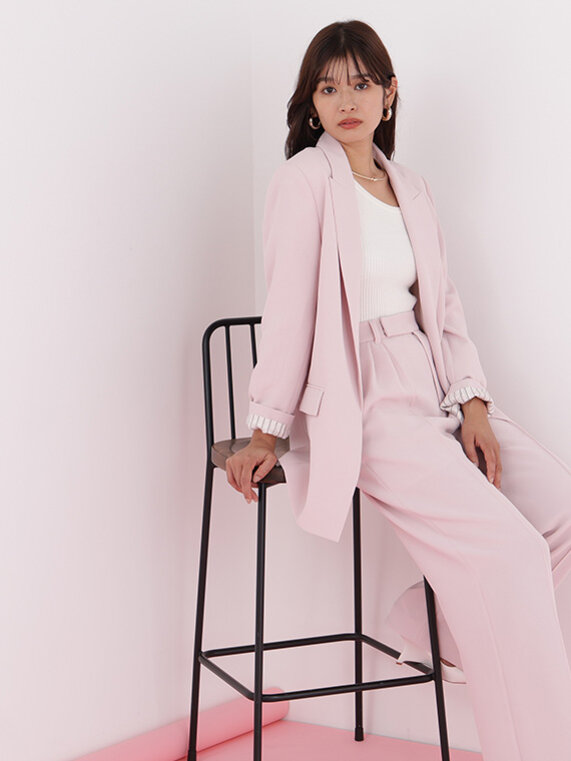 ベイビーピンクのコートにブラックのニットプルオーバー、ホワイトのロングスカートのコーディネート