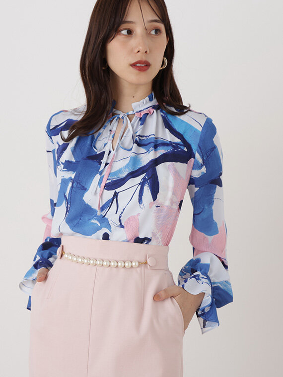 ブルーの柄ブラウスとウエストパール付きのべーびーピンクのタイトスカートのコーディネート