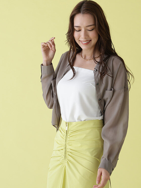 モカカラーのシャツを羽織に、ホワイトのインナーキャミとイエローのタイトスカート