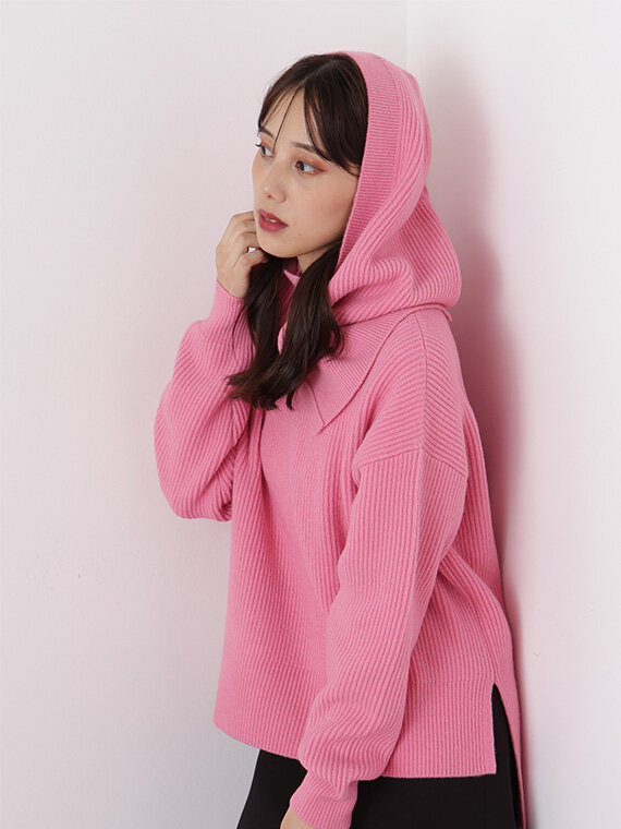 ピンクのバラクラバ付きニットにブラックのミニスカートを合わせたコーディネート