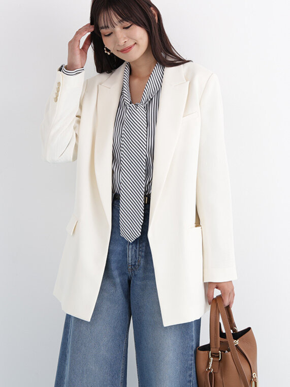 アイボリーのジャケットにストライプ柄のブラウス×デニムワイドパンツ。ブラウンのバッグ合わせ。