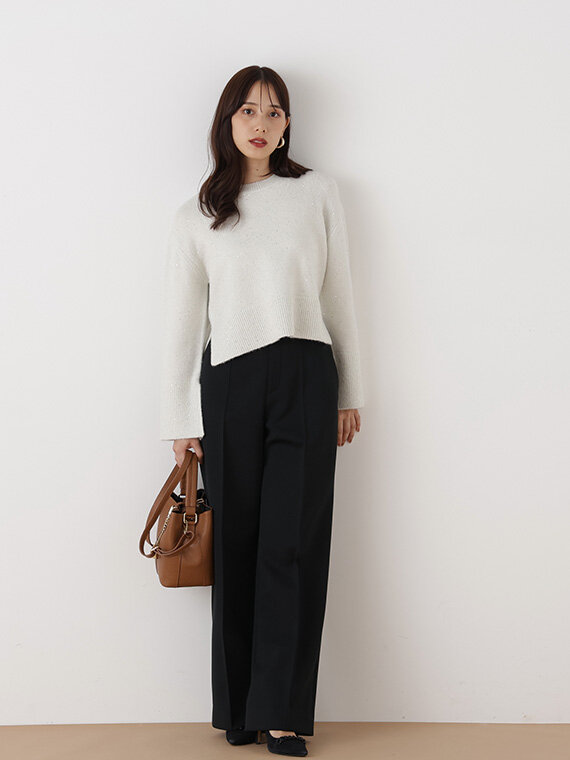 ベージュのラメニットにブラックのストレートパンツ、ブラウンのバッグを合わせたコーディネート