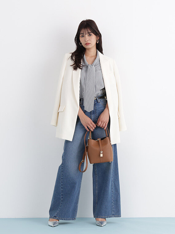 アイボリーのジャケットにストライプ柄のブラウス×デニムワイドパンツ。ブラウンのバッグ合わせ。