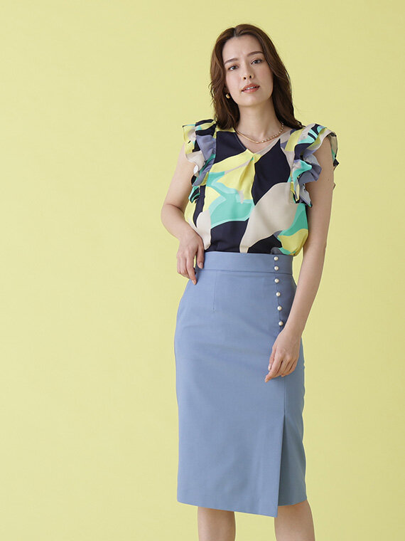 イエローベースの柄ブラウスにブルーのタイトスカート