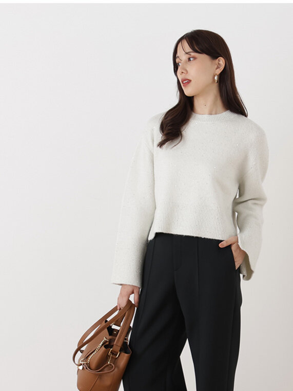 ベージュのラメニットにブラックのストレートパンツ、ブラウンのバッグを合わせたコーディネート