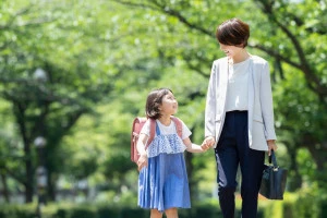 手をつないで歩く母子の写真