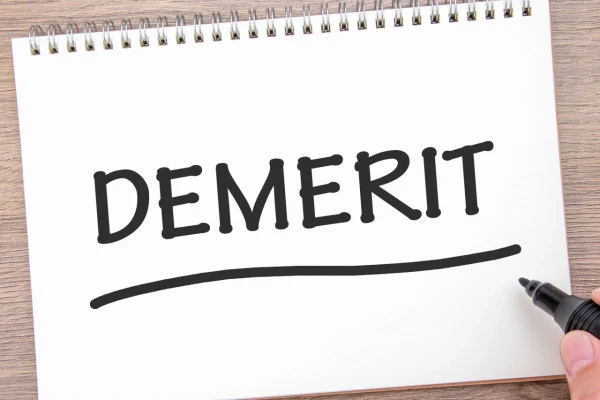 DEMERITと書かれたノートとマーカー