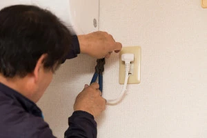 コンセントを取り付ける男性の写真
