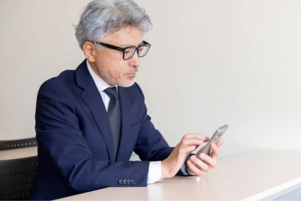 スマートフォンを操作するスーツの中年男性