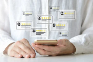 スマホでカスタマーレビューをチェックする人物のイメージ画像