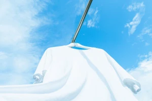 洗濯した白いTシャツと青空の写真