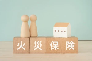 火災保険と書かれたブロックと人形と家の写真