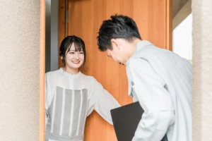 自宅を訪問する作業服姿の男性ビジネスマンの写真