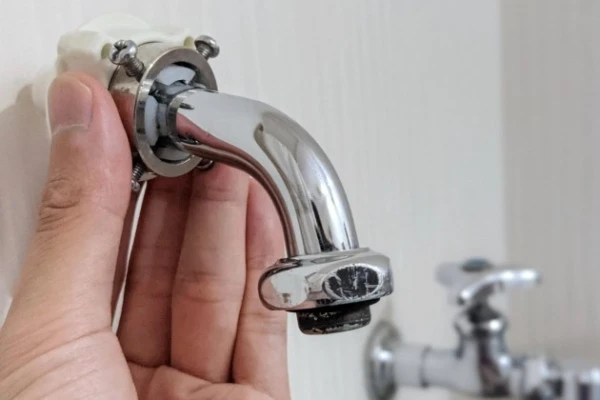 洗濯機の給水ホースから水漏れしたため自分で修理する様子